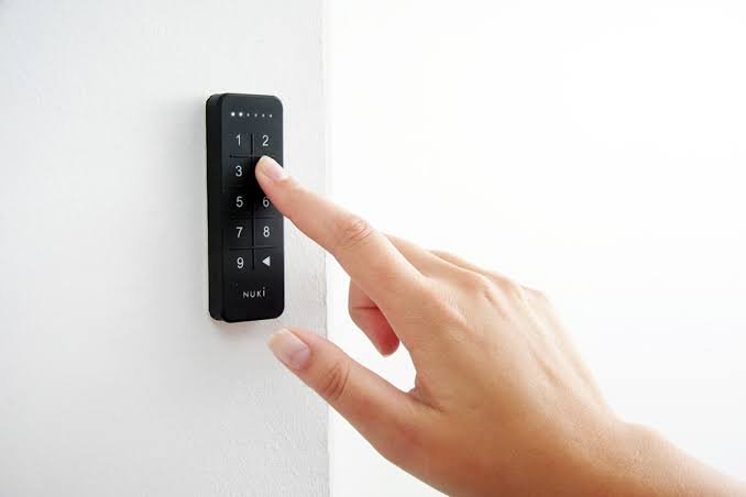 A hand entering a code on the Nuki door keypad